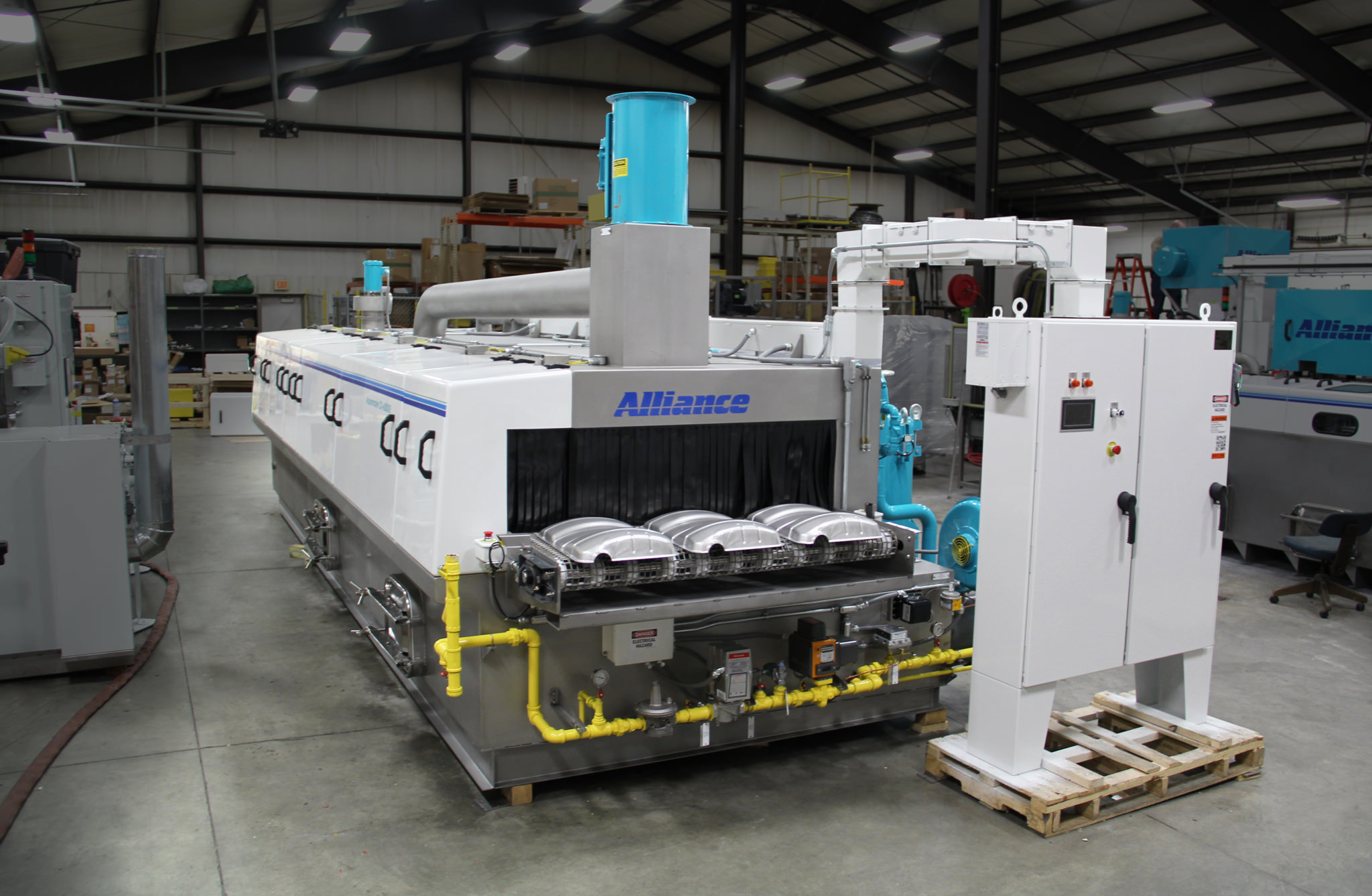 Cleaning stamped parts on an inline part washer